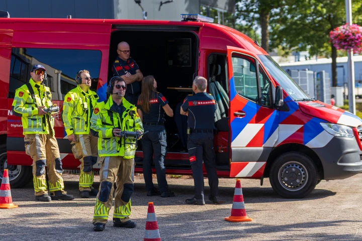 Brandweerspecialisten met drones bij een commandovoertuig tijdens een grote brand in Udenhout